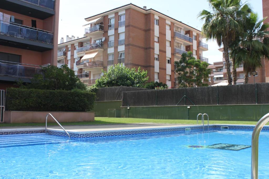 een groot zwembad voor een gebouw bij Fantastic 3 bedroom apartment, 300m to the sea in Lloret de Mar