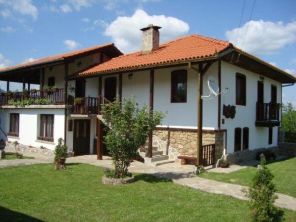 a large white house with an orange roof at Guest House Tsvetina in Apriltsi