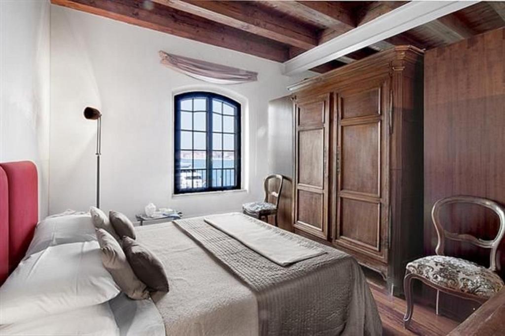 una camera con un grande letto e una finestra di Il Molino Apartment a Venezia