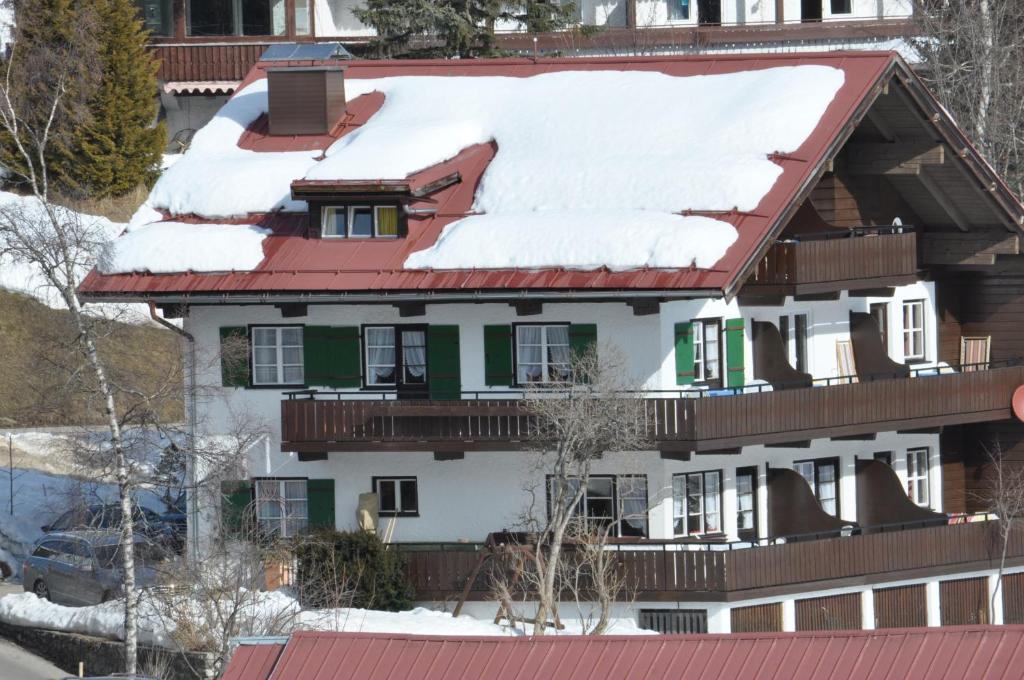 dom ze śniegiem na dachu w obiekcie Herzen´s Landhaus w mieście Hirschegg