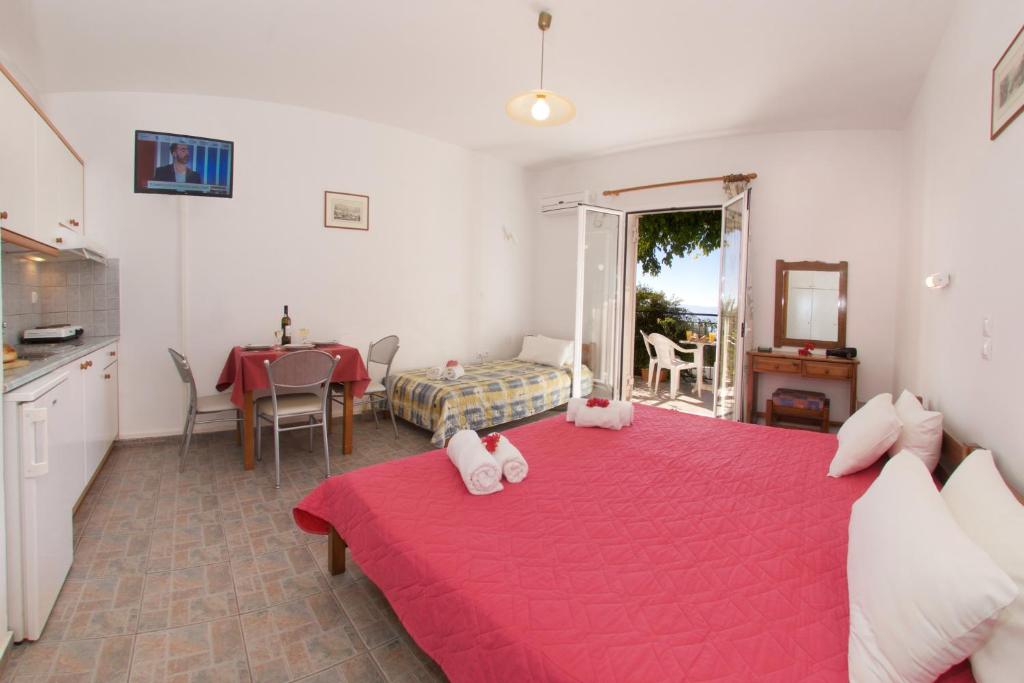 a bedroom with a bed and a table and a kitchen at Summer Dream in Vlachata