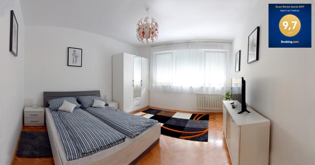 um quarto com uma cama e um lustre em Apartmani Vedmar em Zagreb