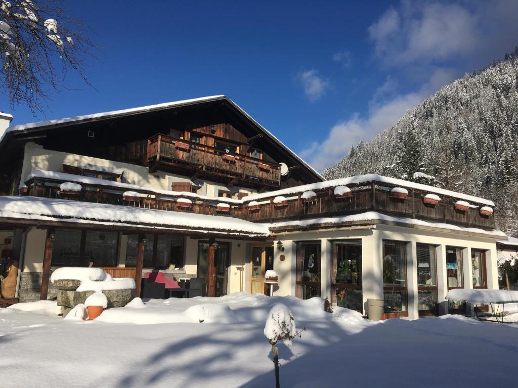 un bâtiment avec de la neige sur le sol devant lui dans l'établissement Chalet l'Aiglon, à Saint-Gervais-les-Bains
