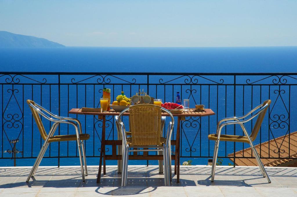 einen Tisch und Stühle auf einem Balkon mit Meerblick in der Unterkunft Summer Dream in Vlachata
