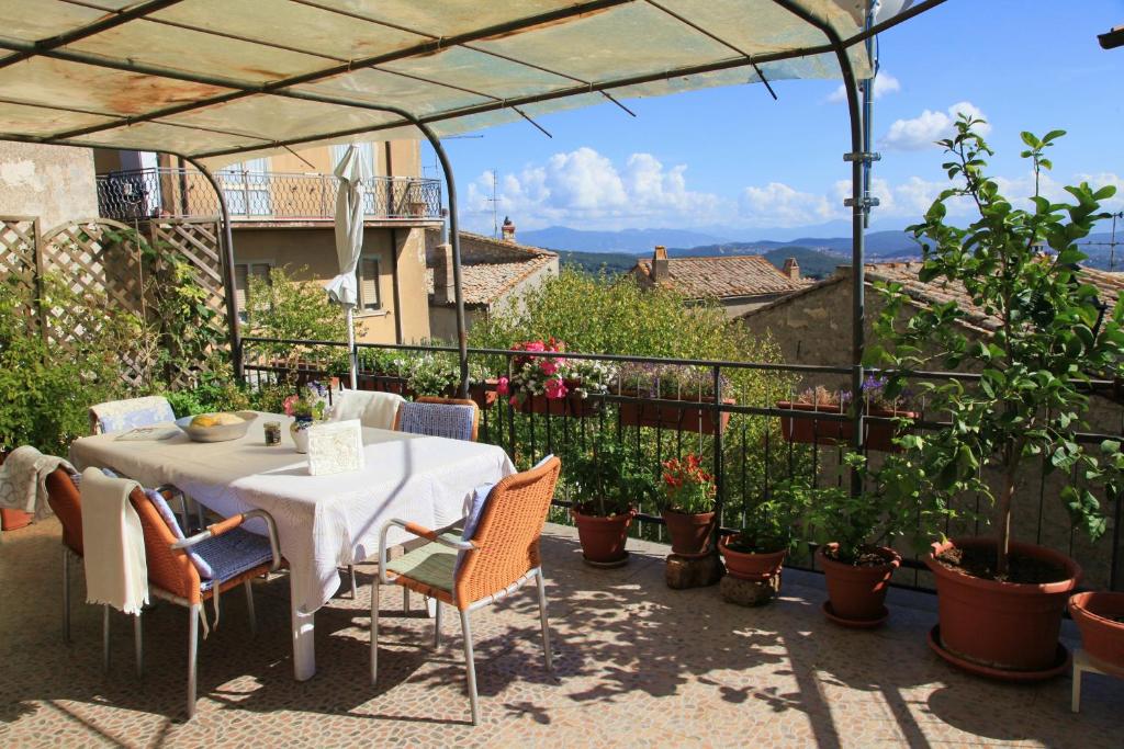 une table et des chaises sur une terrasse agrémentée de plantes dans l'établissement B&B Porchiano del Monte, à Amelia
