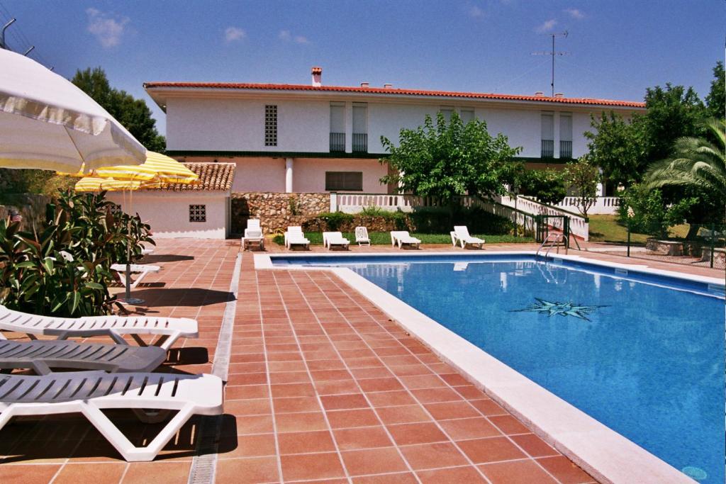 una piscina con sillas y una casa en Can Torrents, en Cunit
