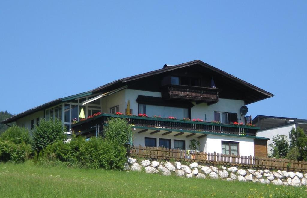 a large white building with a black roof at Garten Apartment Diwoky in Sankt Gilgen