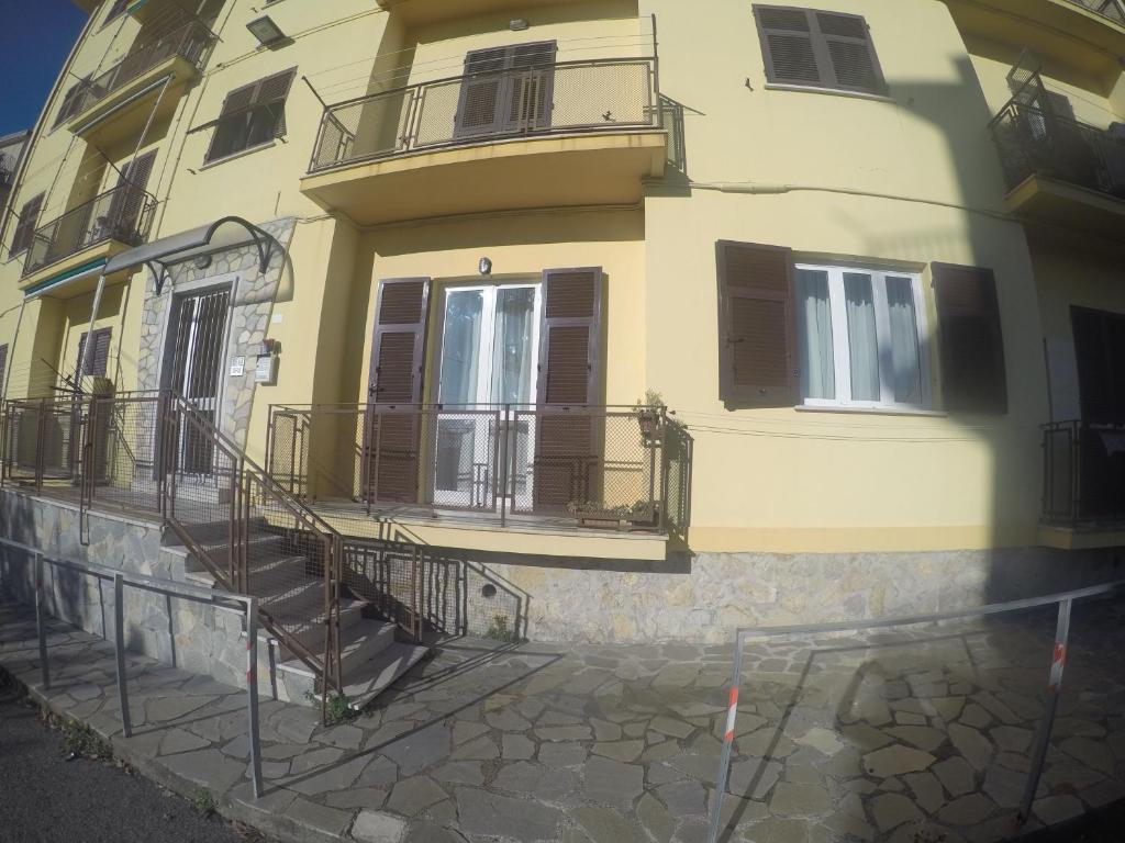 un edificio giallo con scale e balconi di Casa Mire a San Terenzo