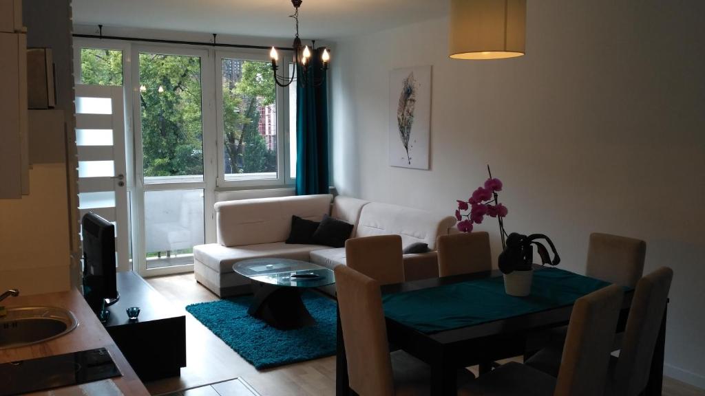 - un salon avec une table et un canapé dans l'établissement Apartament Turkusowy, à Szczecin
