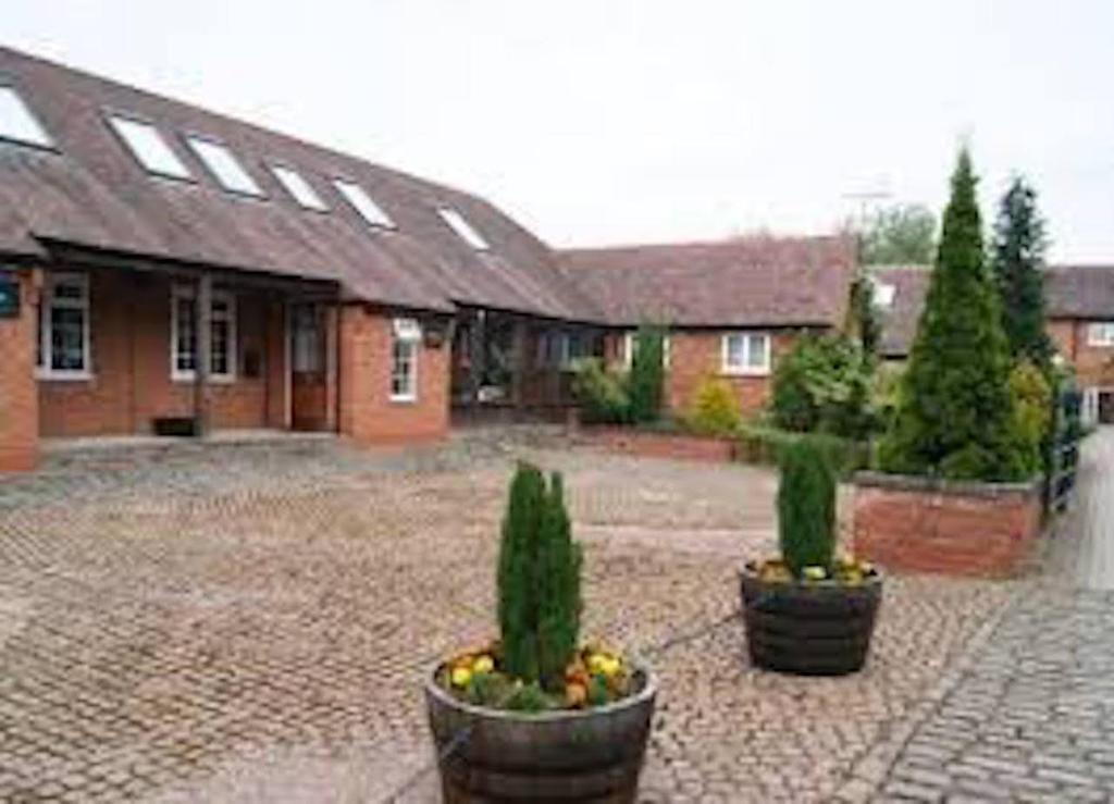 una casa con dos macetas en un patio en Magna en Shilton