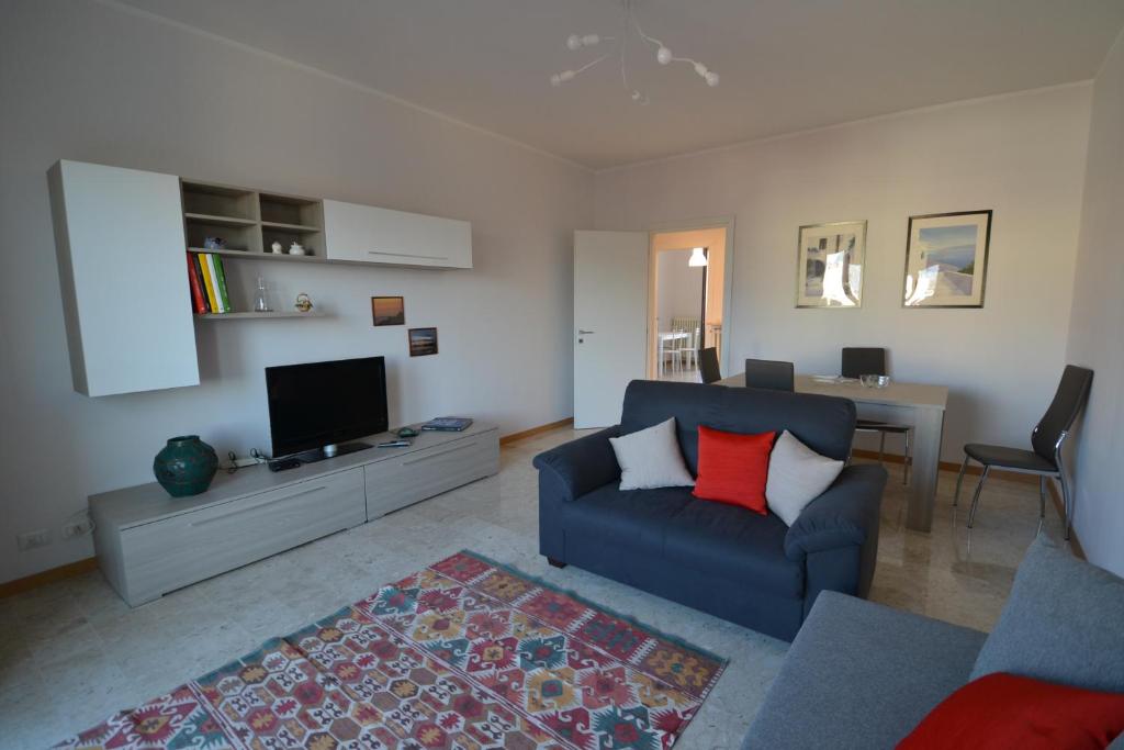 sala de estar con sofá azul y TV en Biroldi Apartment, en Varese
