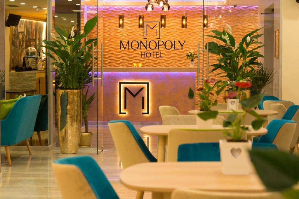 un ristorante con tavoli e sedie e un cartello che legge l'hotel monopolistico di Monopoly Hotel a Otopeni