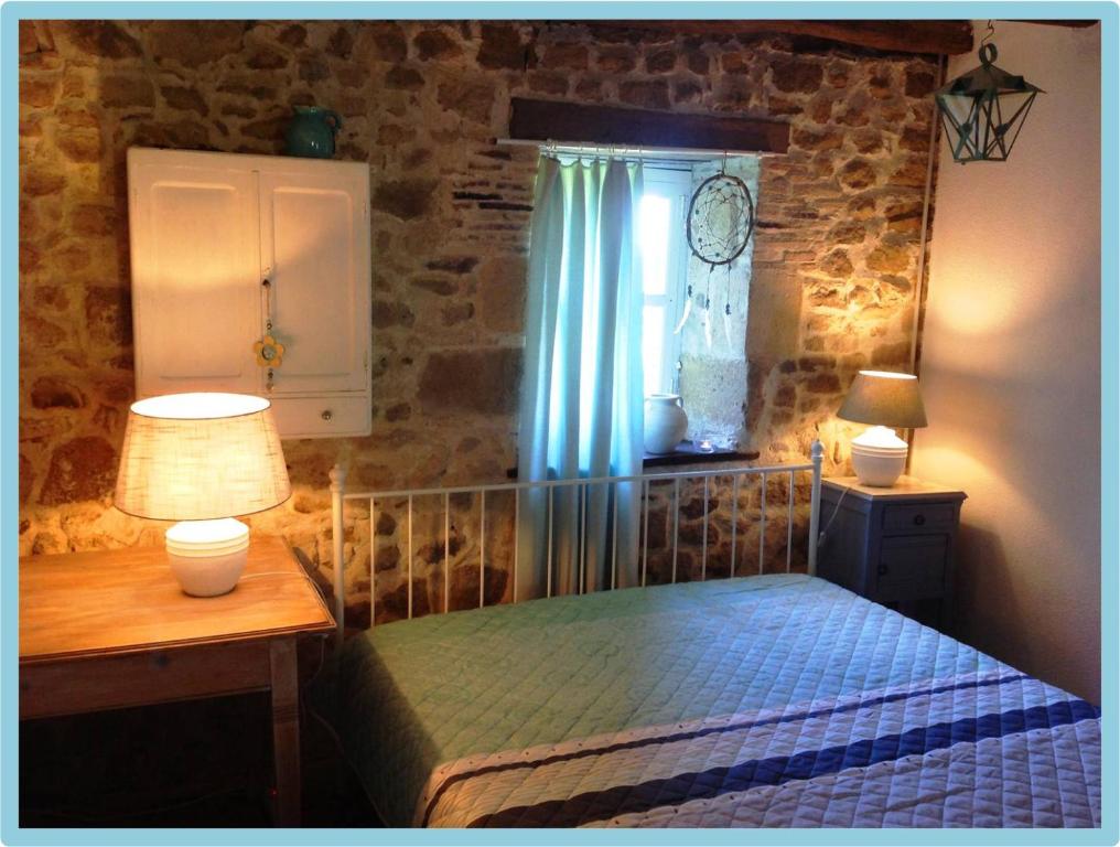 a bedroom with a bed and a table and a window at Domaine Charente Glamping Familyroom Le Jardin with external toilet & shower house & outdoor kitchen in Mazières