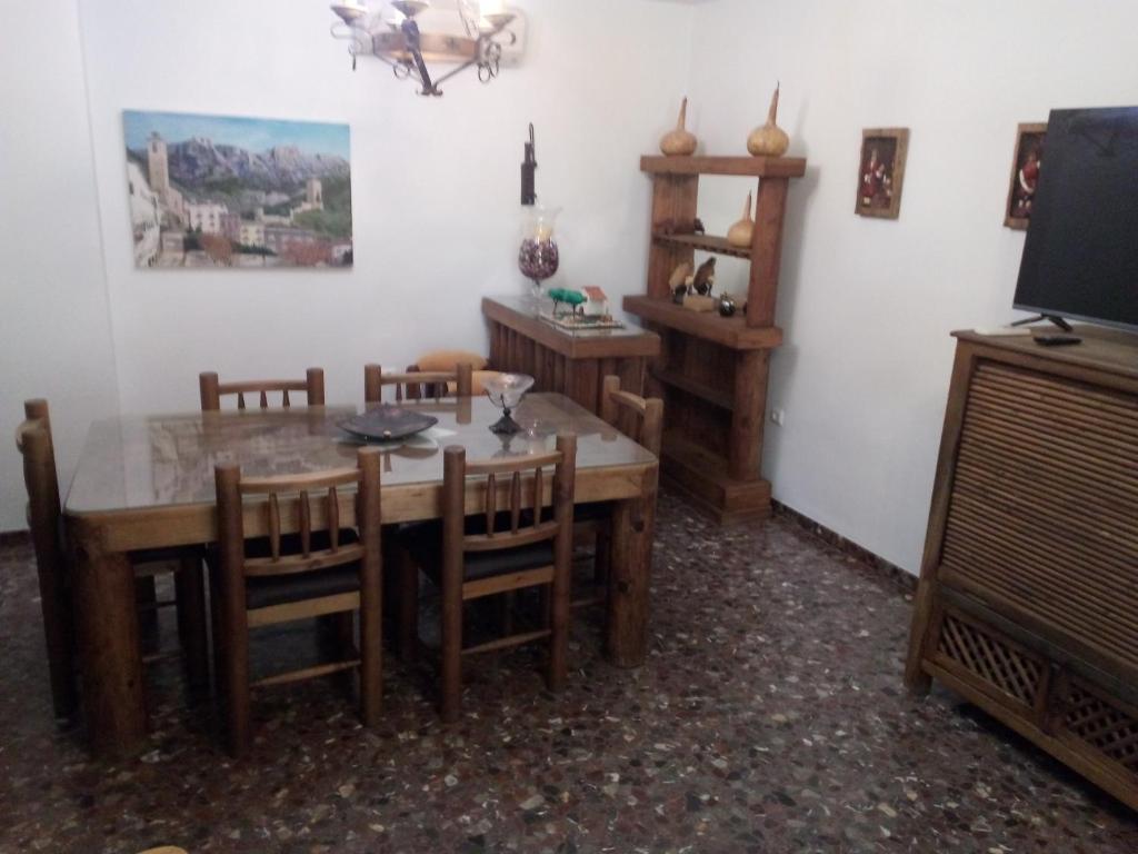 uma sala de jantar com mesa e cadeiras e uma televisão em Casa La Antigua Almazara em Cazorla