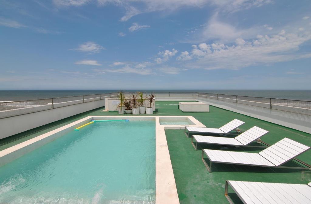 una piscina en la parte superior de un edificio con mar en el hotel Vista a Villa Gesell