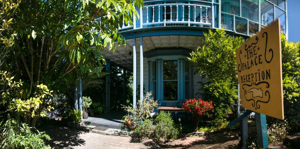 a house with a sign in front of it at The Palace Backpackers in Nelson