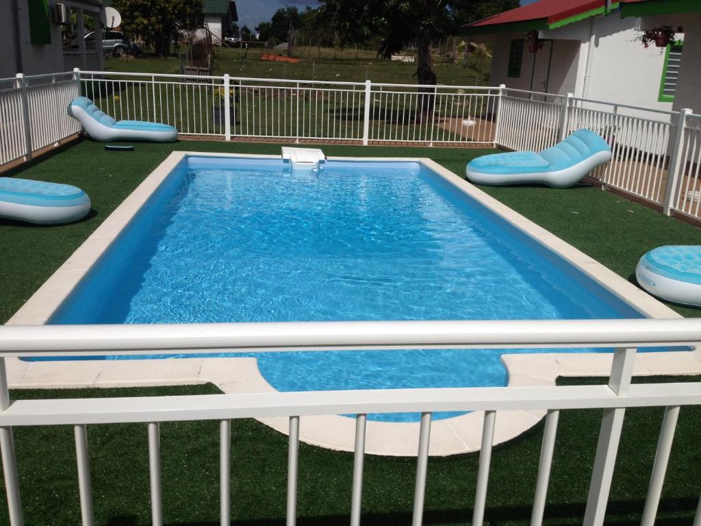 a swimming pool with chairs in a yard at Gites Man-non in Sainte-Anne