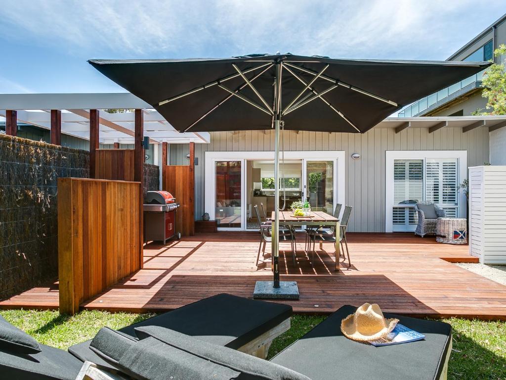 eine Terrasse mit einem Tisch und einem Sonnenschirm in der Unterkunft Capella Villa No. 4 - stunning luxury decor inside and out in Blairgowrie