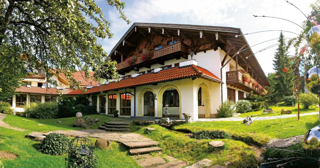 a large house with a garden in front of it at Posthotel Hofherr in Königsdorf