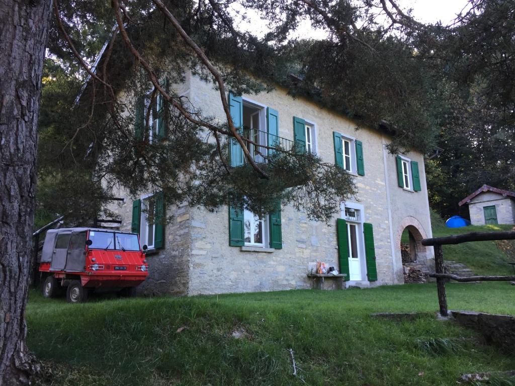 un jeep rojo estacionado frente a una casa en Baita Mirella, en Torno