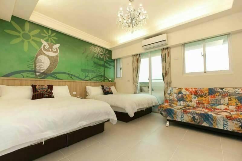 um quarto com 2 camas e uma parede verde em Yoshanshui Inn em Jian