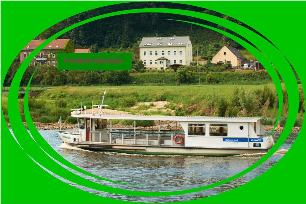 a boat traveling down a river near a town at Pension Hönel-Hof Bad Schandau in Bad Schandau