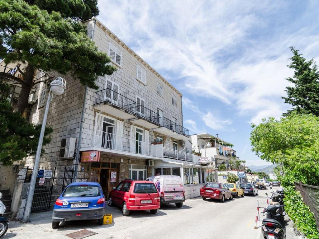 una calle con coches estacionados en el lateral de un edificio en Apartments Deni 10, en Dubrovnik