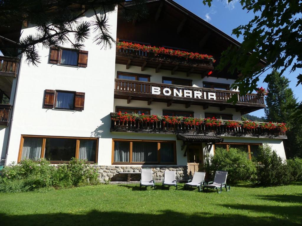 un edificio con un balcón con flores. en Garni Bonaria, en Corvara in Badia