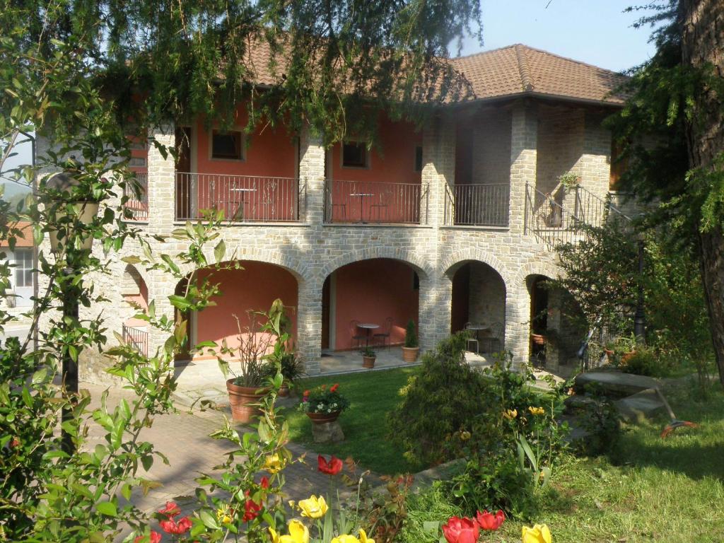 uma casa grande com um quintal com flores em Madonna della Neve em Cessole