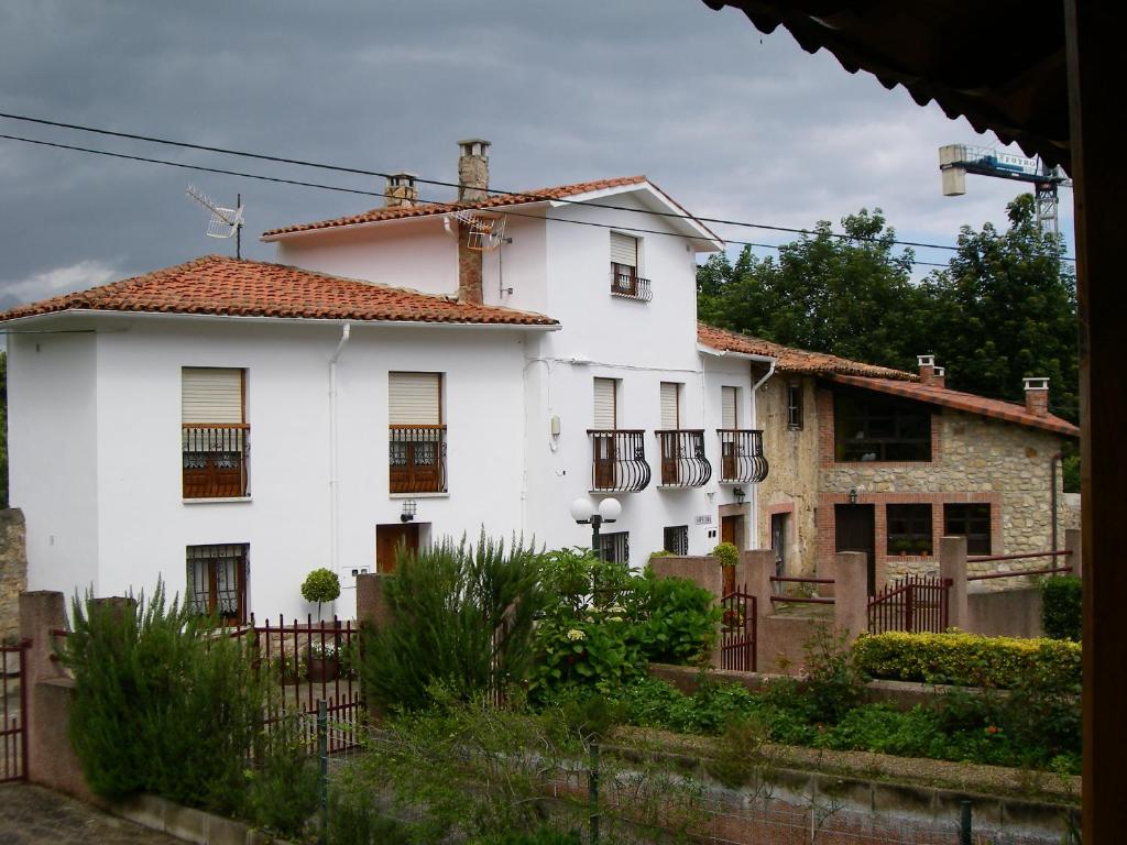 a white house with a fence in front of it at Apartamento Sopiedra in Nueva de Llanes