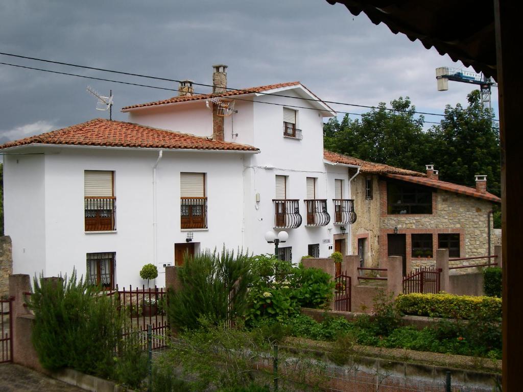 une maison blanche avec une clôture devant elle dans l'établissement Apartamento Sopiedra, à Nueva de Llanes