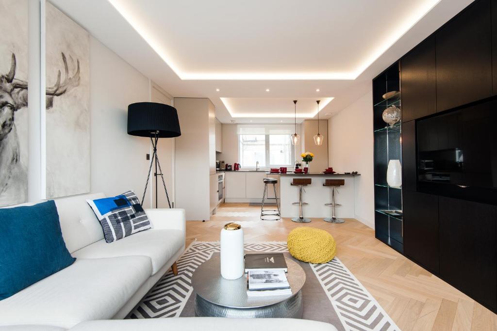 uma sala de estar com um sofá branco e uma mesa em ARCORE Premium Apartments Oxford Street Area em Londres