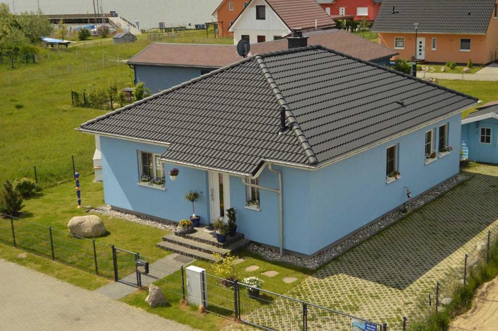 a small blue house with a black roof at FH Das blaue Haus am Peenestrom_BL in Peenemünde