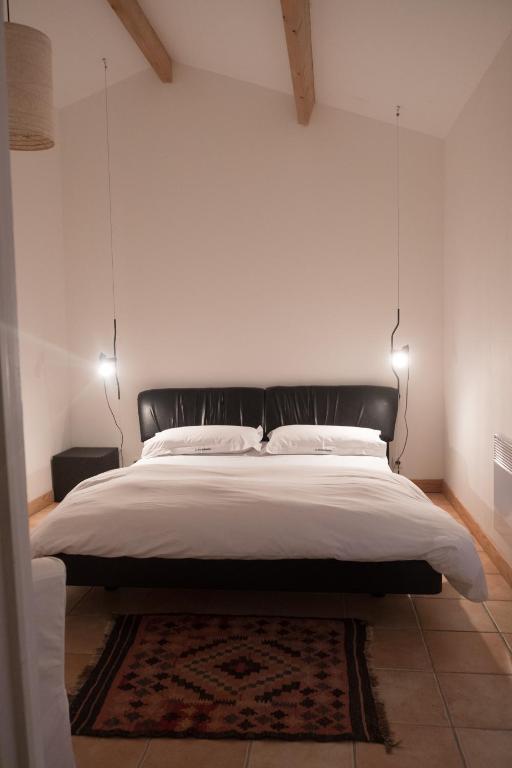 a bedroom with a large bed with two lights at La Bribaudonnière in Saint-Palais-de-Phiolin