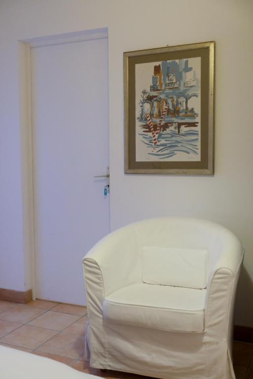 a white chair in a room with a picture on the wall at La Bribaudonnière in Saint-Palais-de-Phiolin