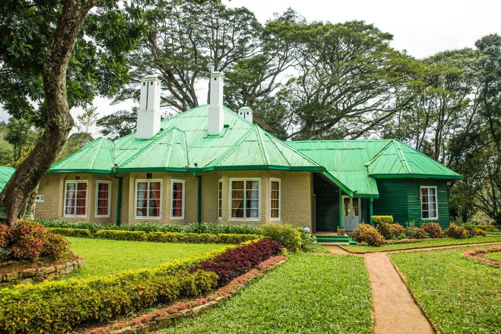 uma casa com um telhado verde num quintal em Royal Majesty Bungalow em Hatton