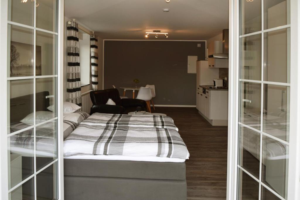 ein Schlafzimmer mit einem Bett in einem Zimmer mit Glaswänden in der Unterkunft Ferienwohnung Palmen in Gangelt