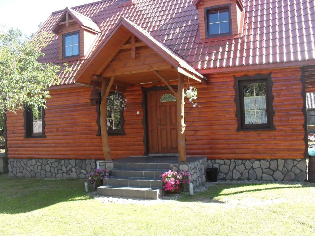 drewniany dom z drzwiami wejściowymi i schodami w obiekcie Pohulanka - Białowieża w mieście Kolonia Pohulanka