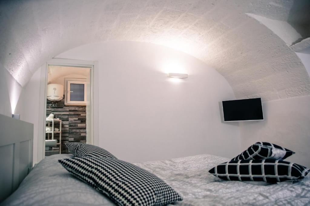 sypialnia z łóżkiem i telewizorem na ścianie w obiekcie Casa Vacanze Antiche Mura E Poi w mieście Monopoli