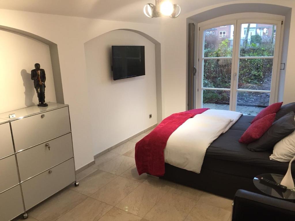 a bedroom with a bed and a dresser and a television at Schlosspark Residenz in Schwerin