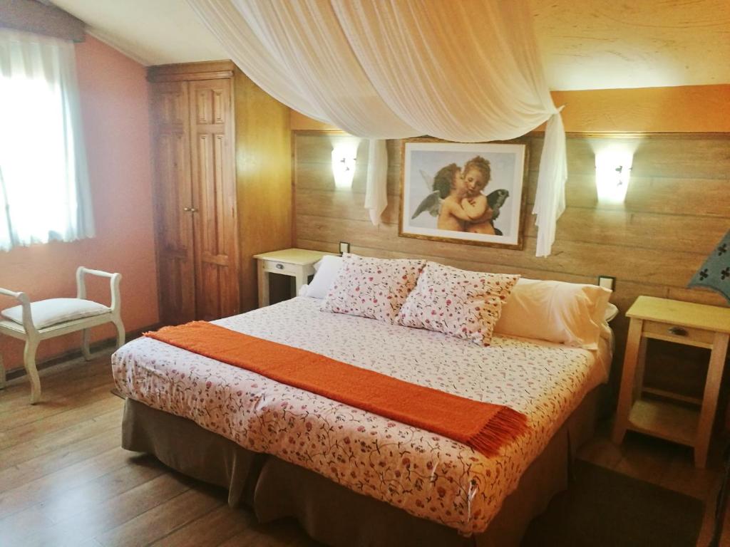 Torrelaguna的住宿－APARTAMENTOS MELCHOR DE LIÑAN，卧室配有一张床,墙上挂着一幅画