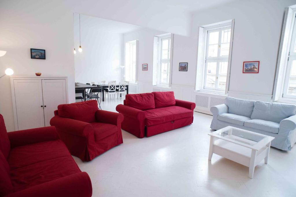 una sala de estar con sofás rojos y una mesa. en Splendid Trees Apartment en Budapest