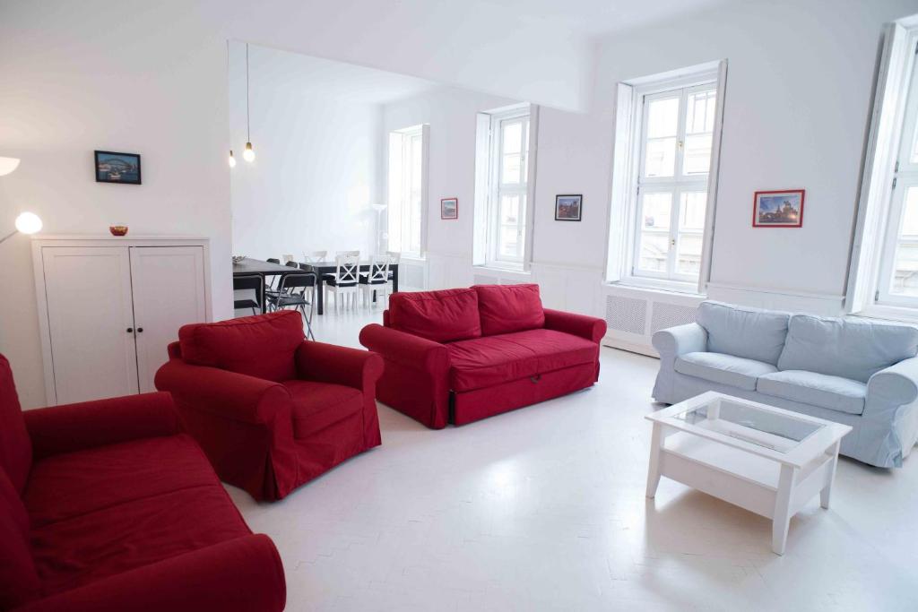 ブダペストにあるSplendid Trees Apartmentのリビングルーム(赤いソファ、テーブル付)