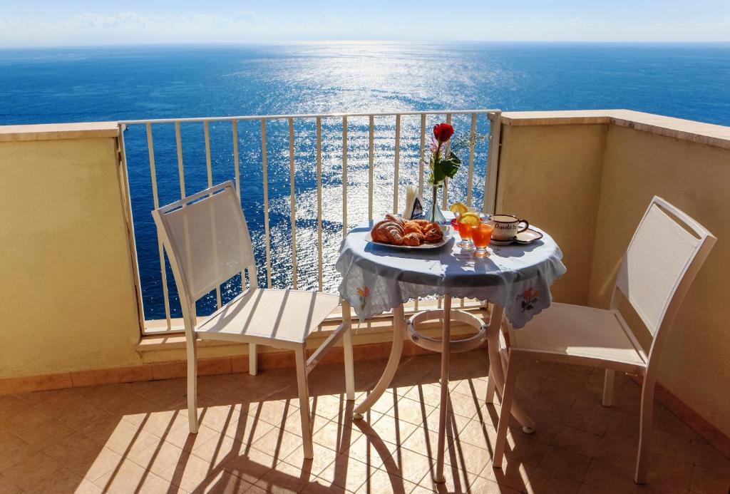 a table with a bowl of fruit on a balcony at Sirenetta in Amalfi