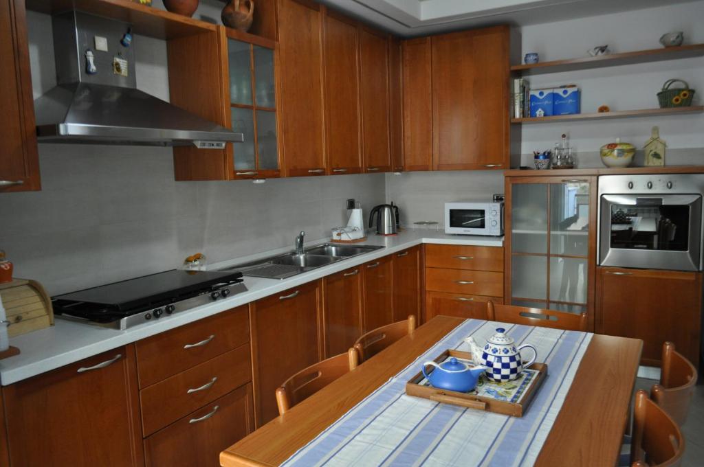 テッラチーナにあるSand 228 Homeのキッチン(木製キャビネット、木製テーブル付)