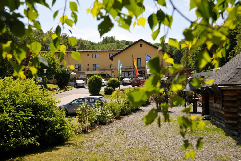 een uitzicht op een straat met een huis en een auto bij Waldhotel Felschbachhof in Ulmet