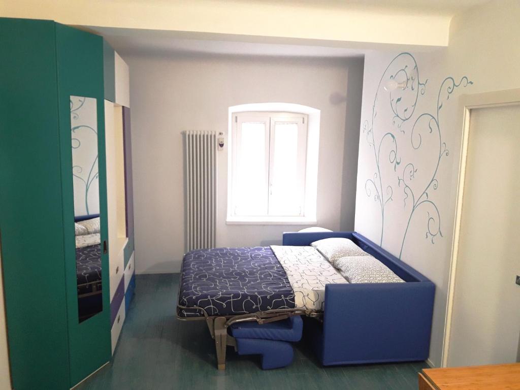 ein Schlafzimmer mit einem blauen Bett und einem Fenster in der Unterkunft La Corte 20 Studio Apartments in Carugo