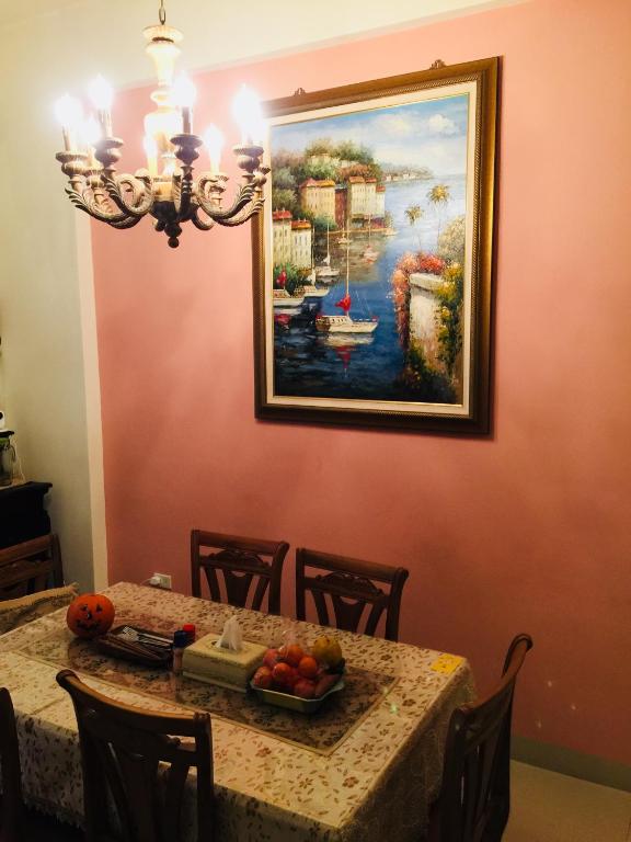 a dining room table with a painting on the wall at Hope &amp; Sea Homestay in Hualien City