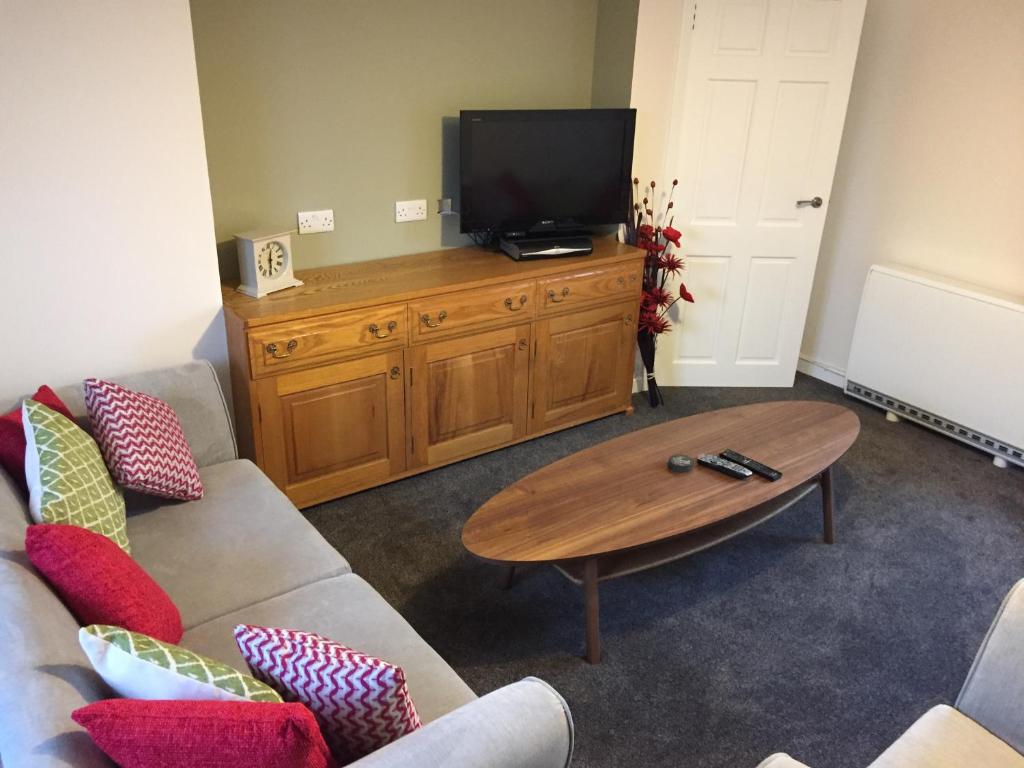 a living room with a television on a wooden dresser at Number 13 in Lerwick