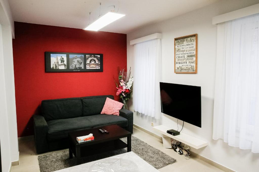 un soggiorno con divano nero e parete rossa di Apartment in Antwerp city centre ad Anversa